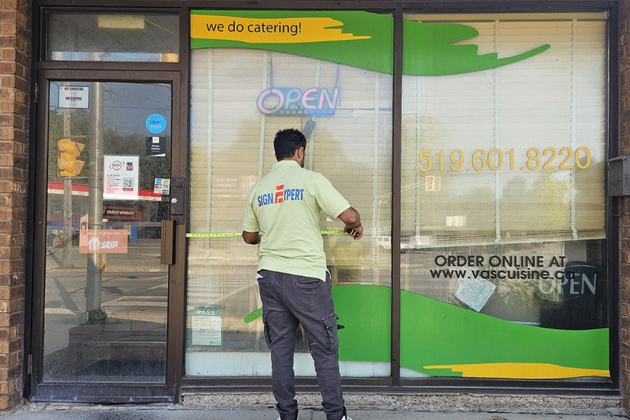 Removing existing vinyl and cleaning the window, Vas Cuisine, London, Ontario
